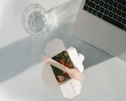 Glass of water and simple lunch on a modern home office desk