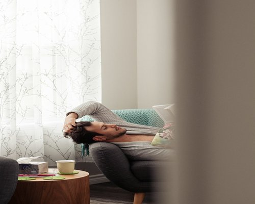 A man relaxing on a sofa in his living room during a quiet evening